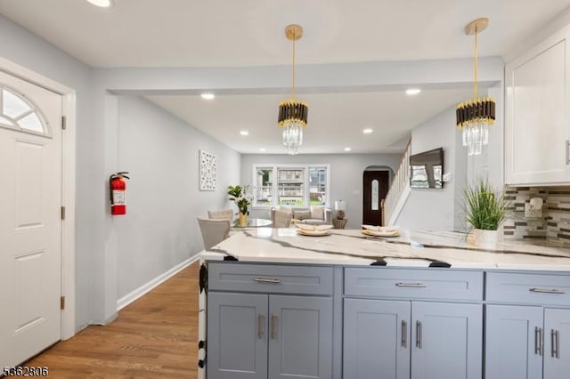 501 E 2nd Ave, Roselle Boro, NJ 07203 - kitchen featuring a chandelier, arched walkways, a peninsula, backsplash, and pendant lighting