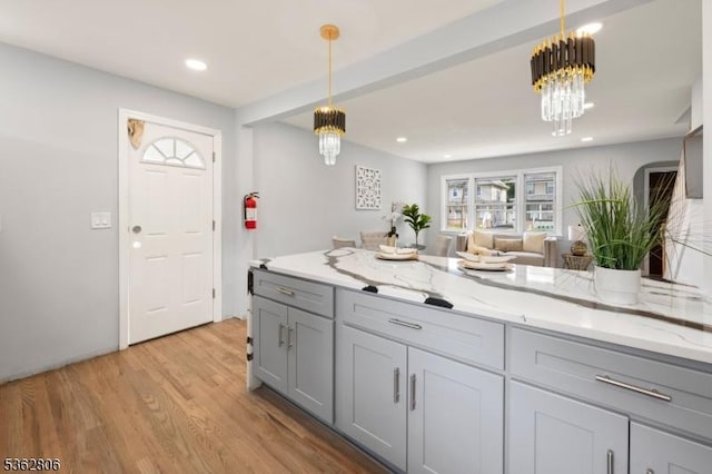 501 E 2nd Ave, Roselle Boro, NJ 07203 - kitchen with gray cabinetry, a chandelier, light wood-style flooring, pendant lighting, and light stone counters