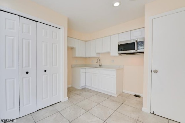 145 S Arlington Ave Unit C, East Orange City, NJ 07018 - kitchen featuring stainless steel microwave, white cabinets, light tile patterned floors, light countertops, and baseboards