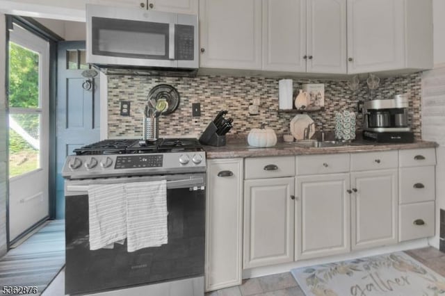 38 Hawthorne Dr, Franklin Twp, NJ 08873 - kitchen with appliances with stainless steel finishes, white cabinetry, decorative backsplash, light stone countertops, and a sink