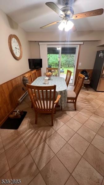 89 Mackerley Rd, Green Twp, NJ 07860 - dining space with wooden walls, wainscoting, a ceiling fan, light tile patterned floors, and a baseboard heating unit