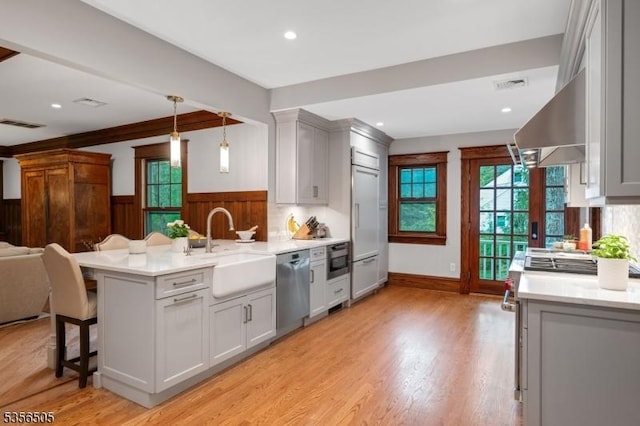 34 Crane Rd, Mountain Lakes Boro, NJ 07046 - kitchen featuring dishwasher, a sink, a wainscoted wall, light countertops, and a kitchen bar