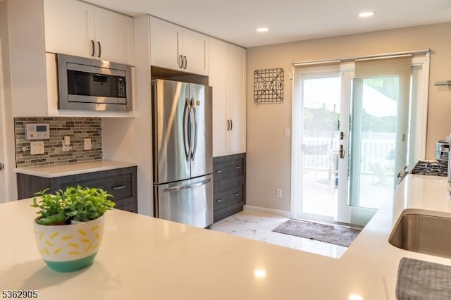 550 Melrose Ave, South Plainfield Boro, NJ 07080 - kitchen with stainless steel appliances, light countertops, decorative backsplash, white cabinetry, and light marble finish floors