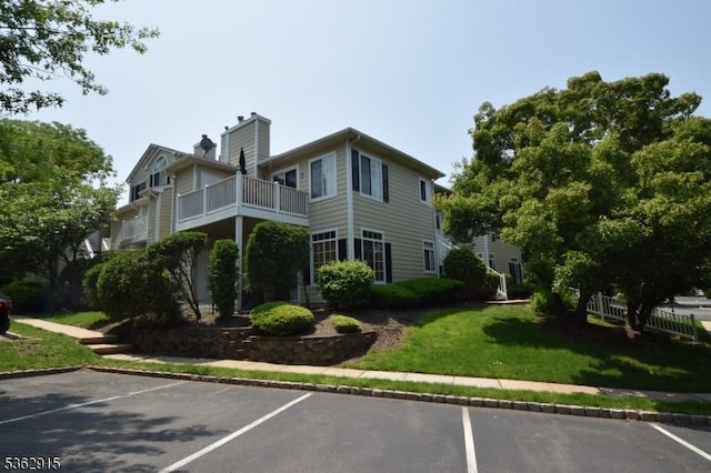 97 Wescott Rd, Bedminster Twp, NJ 07921 - view of home's exterior featuring a balcony, uncovered parking, a chimney, and a lawn