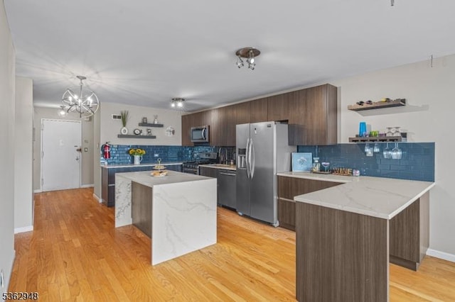 7002 Kennedy Blvd Unit 36G, Guttenberg Town, NJ 07093 - kitchen featuring open shelves, appliances with stainless steel finishes, a kitchen island, and decorative backsplash
