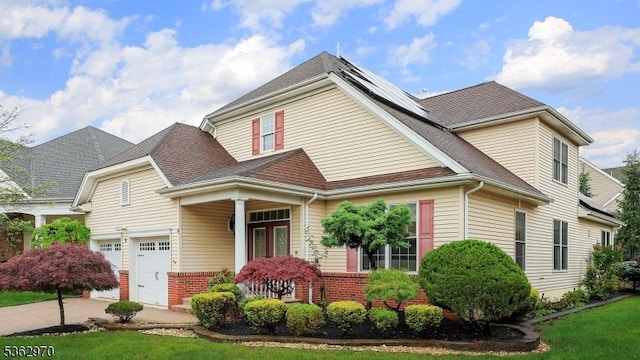 9 Independence Ct, Franklin Twp, NJ 08873 - view of front of property featuring a porch, brick siding, concrete driveway, roof mounted solar panels, and roof with shingles