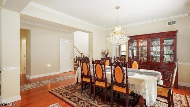 9 Independence Ct, Franklin Twp, NJ 08873 - dining room featuring a chandelier, wood finished floors, stairs, and ornamental molding