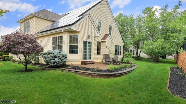 9 Independence Ct, Franklin Twp, NJ 08873 - rear view of property featuring roof mounted solar panels, a lawn, and a patio area