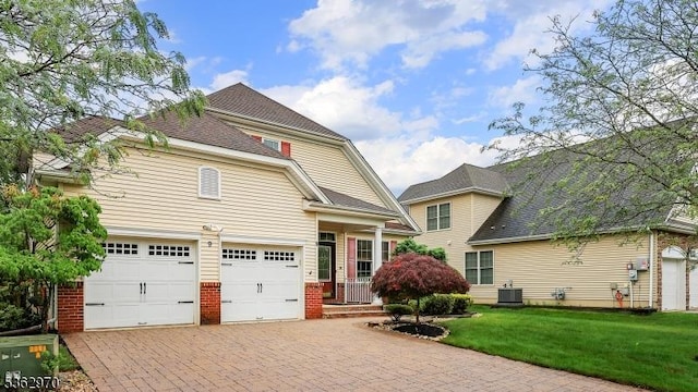 9 Independence Ct, Franklin Twp, NJ 08873 - view of front of home with brick siding, a front yard, decorative driveway, a garage, and roof with shingles