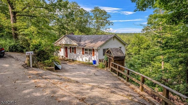 16 Sunset Trl, Rockaway Twp, NJ 07866 - view of front of house with a chimney, driveway, and a forest view