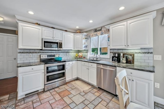 500 Charlestown Rd, Bethlehem Twp, NJ 08827 - kitchen featuring appliances with stainless steel finishes, crown molding, white cabinets, dark stone counters, and decorative backsplash