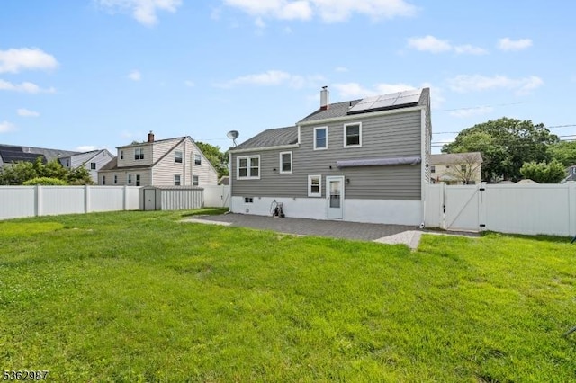 315 D St, Middlesex Boro, NJ 08846 - back of property with a gate, a patio, and roof mounted solar panels
