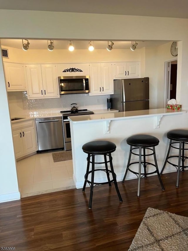 2 Claridge Dr Unit 7Ie, Verona Twp, NJ 07044 - kitchen featuring appliances with stainless steel finishes, a kitchen breakfast bar, and white cabinetry