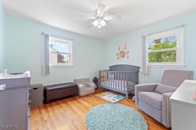 95 1st Ave, Woodbridge Twp, NJ 07064 - bedroom featuring multiple windows, light wood-style flooring, a nursery area, and ceiling fan