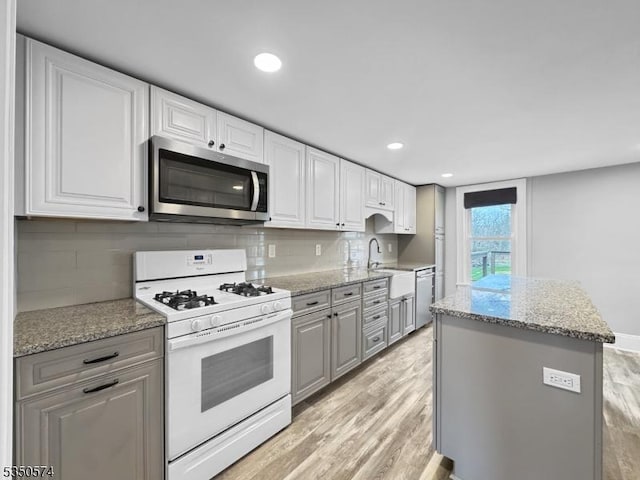 150 Mt Salem Rd, Wantage Twp, NJ 07461 - kitchen with stainless steel appliances, a sink, light wood-type flooring, a kitchen island, and tasteful backsplash