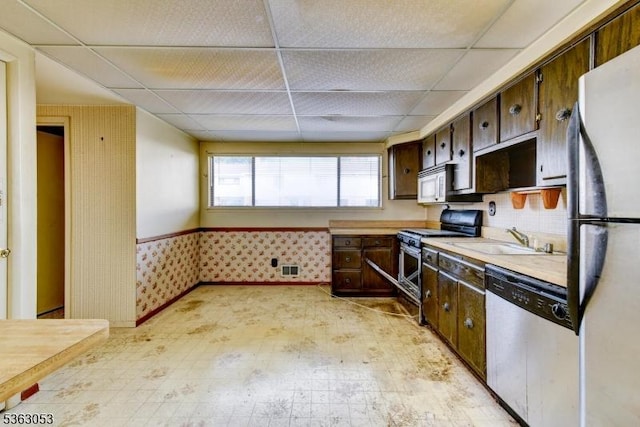 902E Merritt Dr, Hillsborough Twp, NJ 08844 - kitchen featuring appliances with stainless steel finishes, a drop ceiling, light countertops, a sink, and dark brown cabinetry