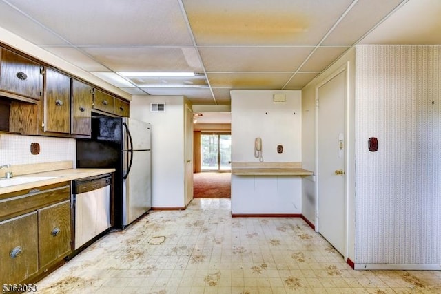 902E Merritt Dr, Hillsborough Twp, NJ 08844 - kitchen featuring stainless steel dishwasher, a sink, light countertops, baseboards, and freestanding refrigerator