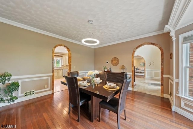 6 Fellen Pl, Hillsborough Twp, NJ 08844 - dining room featuring arched walkways, a decorative wall, hardwood / wood-style flooring, and a wainscoted wall
