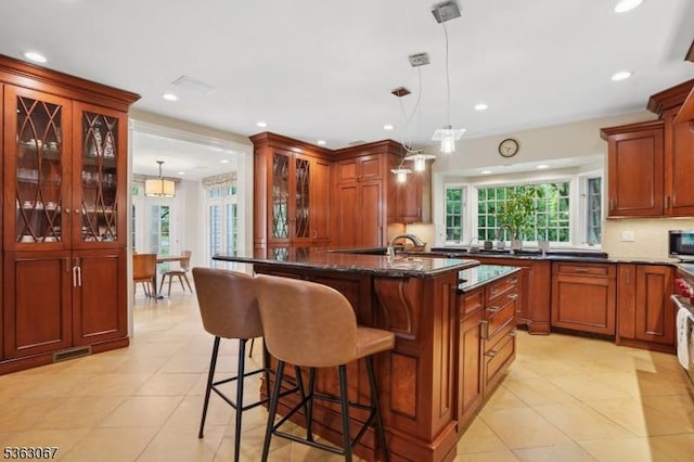 34 Oak Bend Rd, West Orange Twp, NJ 07052 - kitchen featuring glass insert cabinets, light tile patterned flooring, a kitchen bar, dark stone countertops, and recessed lighting