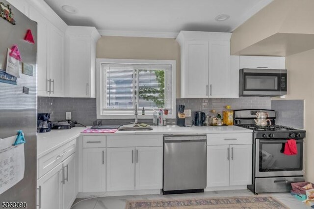 451 Centre St, Nutley Twp, NJ 07110 - kitchen featuring appliances with stainless steel finishes, a sink, light countertops, white cabinetry, and crown molding