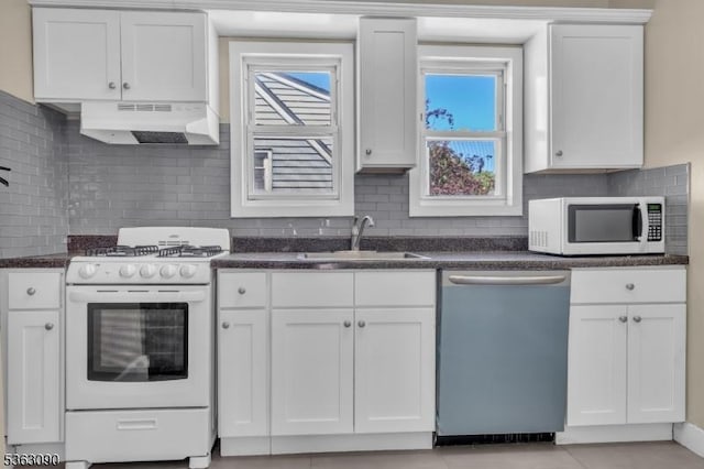 451 Centre St, Nutley Twp, NJ 07110 - kitchen with white appliances, a sink, under cabinet range hood, white cabinets, and healthy amount of natural light