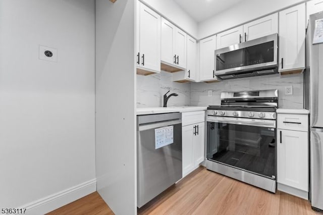 20 Beaconsfield Pl, Franklin Twp, NJ 08873 - kitchen with stainless steel appliances, light countertops, light wood-type flooring, white cabinets, and backsplash