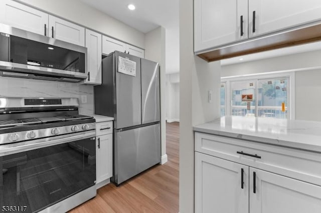 20 Beaconsfield Pl, Franklin Twp, NJ 08873 - kitchen featuring stainless steel appliances, light wood-type flooring, backsplash, white cabinets, and light stone counters