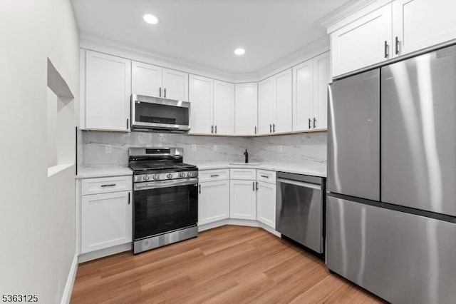 35 Amethyst Way, Franklin Twp, NJ 08823 - kitchen featuring stainless steel appliances, light wood finished floors, a sink, white cabinetry, and tasteful backsplash