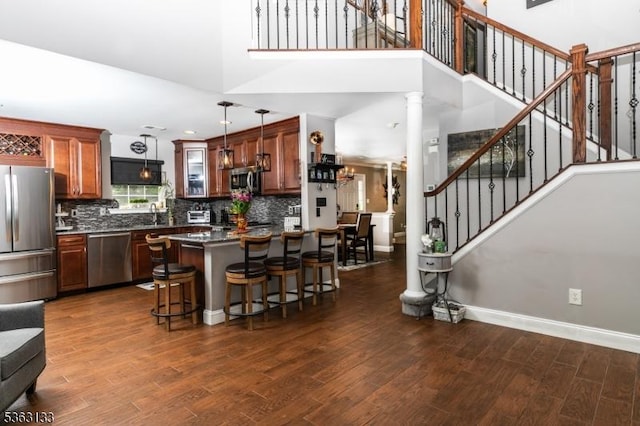 64 Pond Hollow Dr, Jefferson Twp, NJ 07438 - kitchen with stainless steel appliances, dark wood finished floors, a breakfast bar, backsplash, and dark countertops