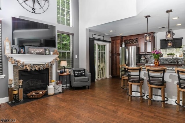 64 Pond Hollow Dr, Jefferson Twp, NJ 07438 - kitchen with dark wood-type flooring, hanging light fixtures, decorative backsplash, open floor plan, and a fireplace with raised hearth