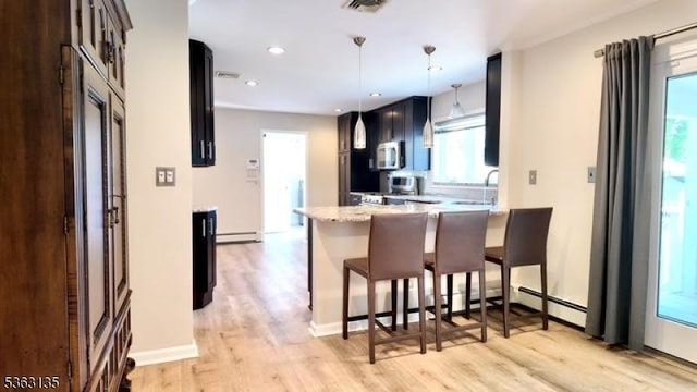 151 2nd St, Franklin Twp, NJ 08873 - kitchen with stainless steel appliances, a peninsula, a breakfast bar area, light wood-style flooring, and hanging light fixtures
