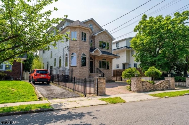 69 Summit Rd, Elizabeth City, NJ 07208 - view of front of house with stone siding, asphalt driveway, and a fenced front yard