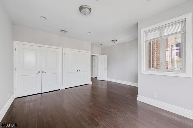 69 Summit Rd, Elizabeth City, NJ 07208 - unfurnished bedroom with baseboards, wood finished floors, and two closets