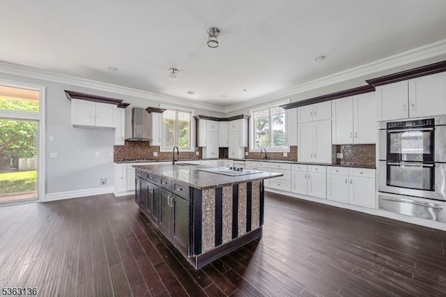 69 Summit Rd, Elizabeth City, NJ 07208 - kitchen with a warming drawer, wall chimney range hood, stainless steel double oven, a sink, and dark wood-type flooring
