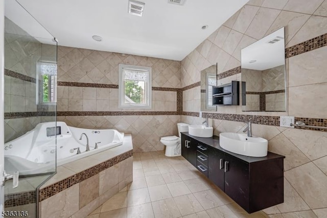 69 Summit Rd, Elizabeth City, NJ 07208 - bathroom with tile walls, a whirlpool tub, double vanity, healthy amount of natural light, and tile patterned flooring