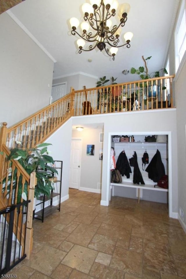 132 Sloop Rd, Stafford Twp, NJ 08050 - staircase featuring stone tile flooring, a chandelier, a towering ceiling, crown molding, and baseboards