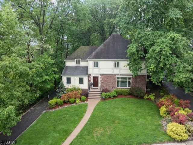 460 Overhill Rd, South Orange Village Twp, NJ 07079 - tudor house featuring a front lawn, stucco siding, brick siding, and roof with shingles