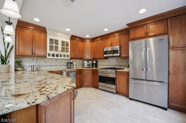 157 Rock Rd, Wayne Twp, NJ 07470 - kitchen featuring appliances with stainless steel finishes, light stone countertops, decorative backsplash, brown cabinets, and recessed lighting