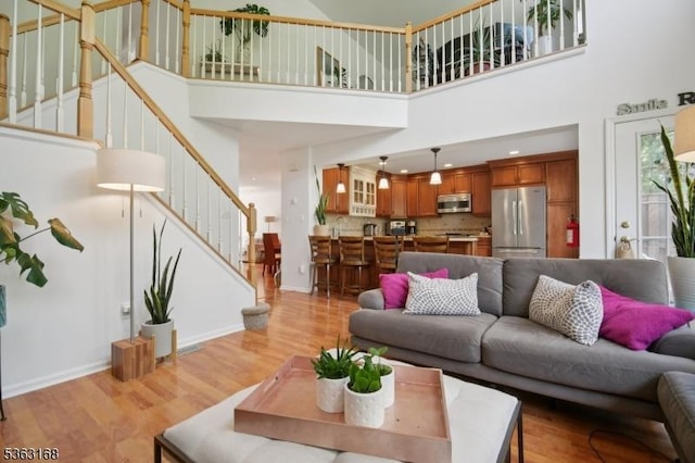 157 Rock Rd, Wayne Twp, NJ 07470 - living area featuring a towering ceiling, stairway, light wood-style floors, and baseboards
