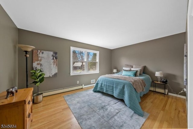 304 Lilac Ct, Bridgewater Twp, NJ 08807 - bedroom featuring baseboard heating, light wood-style flooring, and baseboards