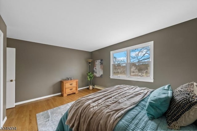 304 Lilac Ct, Bridgewater Twp, NJ 08807 - bedroom featuring a baseboard heating unit, wood finished floors, and baseboards