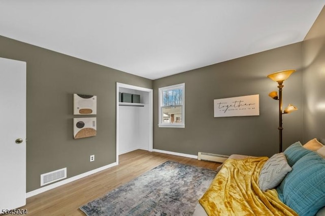 304 Lilac Ct, Bridgewater Twp, NJ 08807 - living area with a baseboard heating unit, wood finished floors, and baseboards