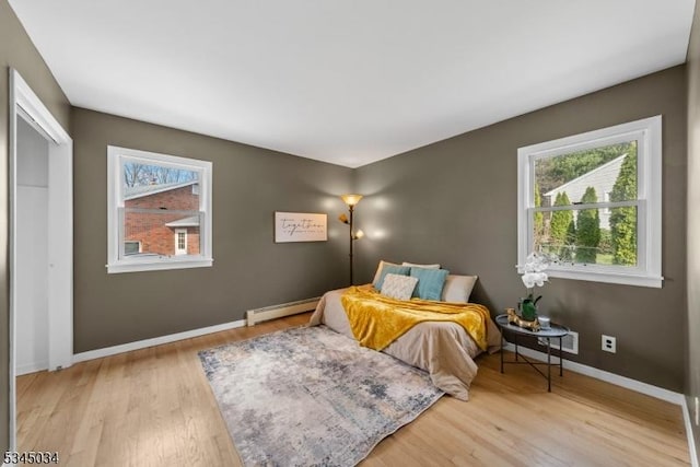 304 Lilac Ct, Bridgewater Twp, NJ 08807 - bedroom featuring a baseboard radiator, wood finished floors, and multiple windows