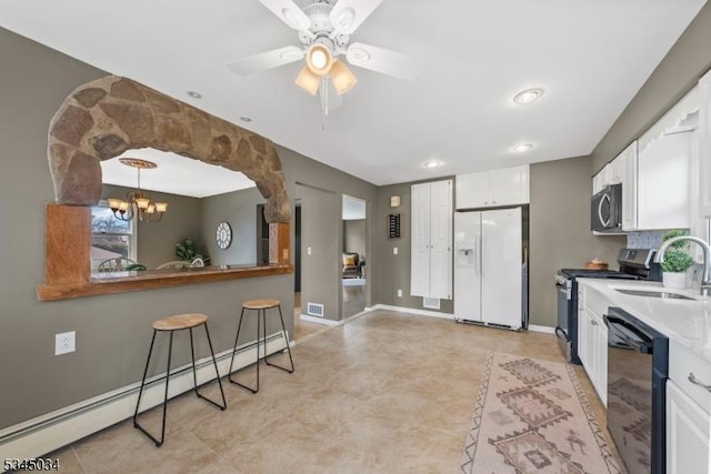 304 Lilac Ct, Bridgewater Twp, NJ 08807 - kitchen featuring stainless steel appliances, a sink, white cabinets, a baseboard heating unit, and a chandelier