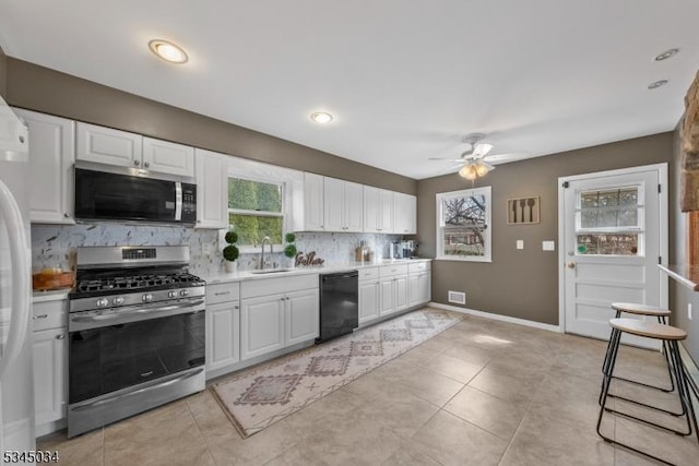 304 Lilac Ct, Bridgewater Twp, NJ 08807 - kitchen with stainless steel appliances, a sink, decorative backsplash, a ceiling fan, and white cabinetry