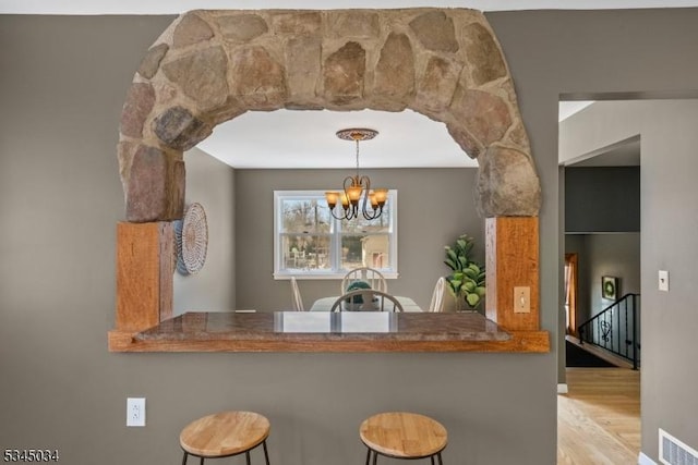 304 Lilac Ct, Bridgewater Twp, NJ 08807 - kitchen with a chandelier, wood finished floors, a kitchen bar, and hanging light fixtures