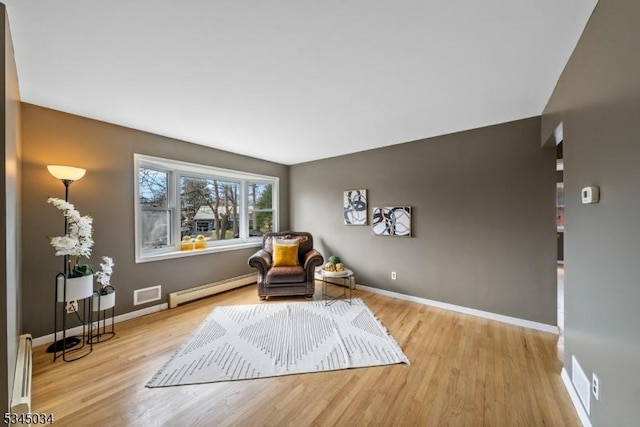 304 Lilac Ct, Bridgewater Twp, NJ 08807 - living area featuring a baseboard heating unit, baseboard heating, wood finished floors, and baseboards