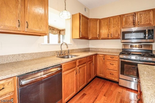 8 Staudt Ct, Franklin Twp, NJ 08873 - kitchen with stainless steel appliances, a sink, wood finished floors, and brown cabinetry