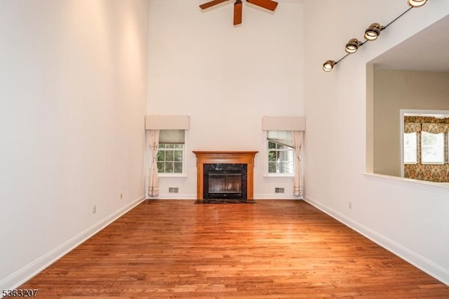 8 Staudt Ct, Franklin Twp, NJ 08873 - unfurnished living room featuring a high ceiling, ceiling fan, wood finished floors, a fireplace, and baseboards