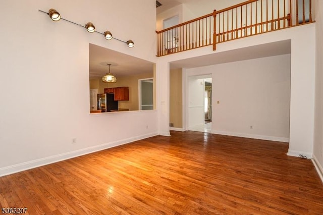 8 Staudt Ct, Franklin Twp, NJ 08873 - unfurnished living room featuring a high ceiling, wood finished floors, and baseboards